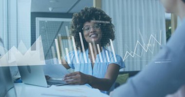 Çizgili bluz giyen kadın raporu inceleniyor. Ofis toplantısında dizüstü bilgisayarlı gözlük takıyor. İş, işbirliği, analitik, profesyonellik, yenilik, işyeri, strateji