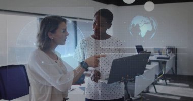 Ofiste dizüstü bilgisayarla etkileşime giren iki meslektaşın dünya haritası ve çizelgeleri ile analiz ediliyor. Teknoloji, işbirliği, yenilik, üretkenlik, dijital, profesyonel, modern