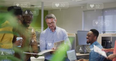 İşaret takımı, sosyal medya simgeleriyle birlikte bürodaki belgeleri inceleyen mavi gömlekli bir ekibin başı. İşbirliği, takım çalışması, ofis, profesyonel, iletişim, modern, kurumsal