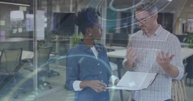 İş arkadaşları dizüstü bilgisayarın ekranını işaret ediyor, verileri açıklıyor, kadın başını sallıyor ve jest yapıyor. İşbirliği, takım çalışması, iletişim, modern, profesyonel, kurumsal, beyin fırtınası