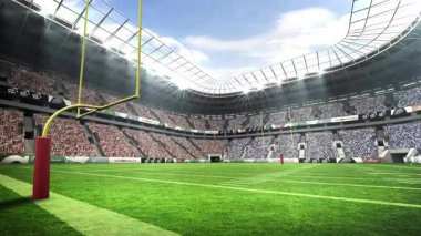 Stadyum manzaralı kamera açılıyor. Kalabalığı ortaya çıkarmak için sarı kale direğine doğru dönüyor. Stadyum, arena, spor, yarışma, atletik, açık hava, seyirciler