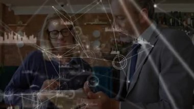 İş ortakları kafede tablet teftişine eğiliyor, analitik ağ grafiklerini örtüyor. İşbirliği, veri görselleştirme, modern çalışma alanı, dijital etkileşim, profesyonel tartışma, yenilik, ağ oluşturma