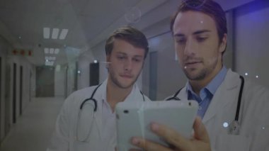 Hastane kayıtlarındaki doktorlar tableti kaydırıyor ve hasta verilerini gözden geçiren verileri etkinleştiriyor. Tıbbi, işbirliği, teknoloji, yenilik, sağlık, analitik, dijital