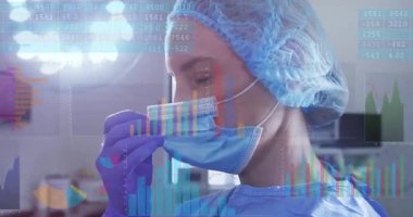 Cerrah, eldiven takmış elleriyle maske takıyor ve ameliyattan önce uyması için maske kaldırıyor. Tıbbi, sağlık, steril, profesyonellik, güvenlik, temiz, klinik