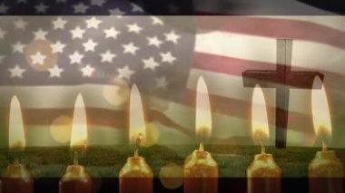 Yavaş sallanan Amerikan bayrağı, yedi mum titreşiyor, çapraz duruyor, meditasyonsal bir övgü oluşturuyor. Vatanseverlik, bağlılık, maneviyat, hatıra, sükunet, sükunet, anıt