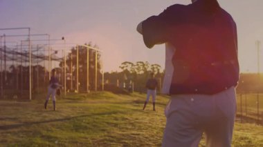 Beyzbol atıcısı topu kıvırıyor ve hareketli yörünge atışlarıyla pratik yapıyor. Atletizm, takım çalışması, fitness, açık hava, canlı, rekabetçi, dayanıklılık