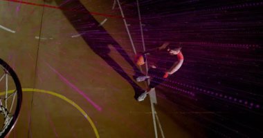 Erkek basketbolcu mor ışıkların altında top sürüyor ve basketbol için potaya doğru atıyor. Sporcu, performans, dinamik, rekabetçi, hareket, enerji, eğlence