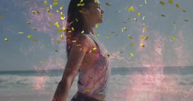 Kumsalda kollarını uzatan bir kadın teknoloji için dönen pembe alevler üreten bir konfeti üretiyor. Dinginlik, kutlama, enerji, yenilenme, canlılık, ruhani, neşe