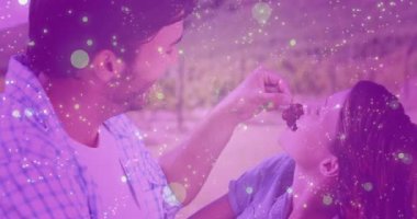 Kırmızı üzümleri eşine doğru kaldıran ve şarap tatmak için üzümleri besleyen bir adam. Romantizm, mahremiyet, bağlantı, açık hava, kırsal, neşeli, boş zaman