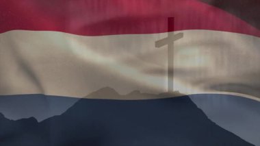 Hafif esinti dalgalı üç renkli bayrak tepedeki haç siluetini örtüyor ve saklanıyor. Vatanseverlik, açık hava, manzara, hareket, kumaş, sembolizm, dinginlik