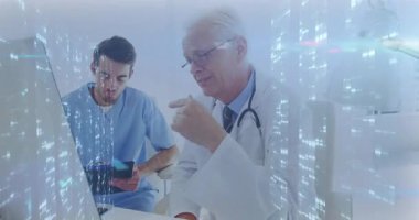 Kıdemli doktor, stajyer sorgularken ve iş birliği yaparken tıbbi verileri açıklayan monitörü işaret ediyor. Danışmanlık, işbirliği, sağlık, meslek, eğitim, eğitim