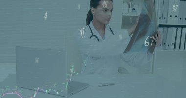 Palto ve steteskop giyen kadın doktor klinikte röntgen filmini inceliyor, dizüstü bilgisayarlı, çizelgeli. Tıbbi, profesyonel, sağlık, tanı, teknoloji, analiz, veri