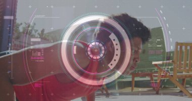 Döşemeli verandada, tahta koltuklarda, HUD kaplamasında kırmızı gömlekli adam şınav çekiyor. Atletik, fitness, teknoloji, açık hava, modern, enerjik, sağlıklı