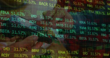 hand holding smartphone displaying digital stock tickers on trading grid, showing live market data. Technology, finance, data, trading, digital, investment, analysis