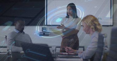 Pointing presenter in suit indicating charts on display in meeting room, with laptops. Corporate, collaboration, professionalism, presentation, digital, modern, teamwork