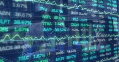 Gesturing male analyst in suit leaning toward transparent screen at office, with stock tickers. Technology, finance, analytics, data, investment, corporate, modern