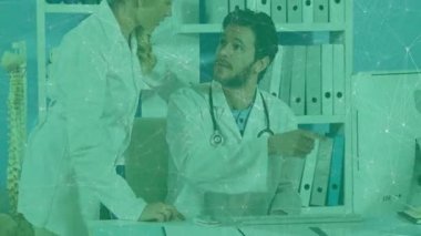 Kadın doktor dosyaya dokunuyor ve erkek doktor monitörü açıklarken ortak inceleme başlatılıyor. Tıbbi personel, işbirliği, profesyonel, sağlık, ergonomik, klinik, takım çalışması