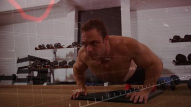 Gömleksiz bir adam şınav çekiyor ve animasyon fitness çizelgesini takip ediyor. Kuvvet, dayanıklılık, eğitim, fizik, fitness, motivasyon, atletizm