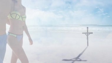 Aşırı nemli kum yansıması, çift yürümeye başlıyor. Tahta haça doğru, seyahat için sarılıyorlar. Romantik, düşünceli, ruhani, minimalist, doğa, dinginlik, samimiyet.