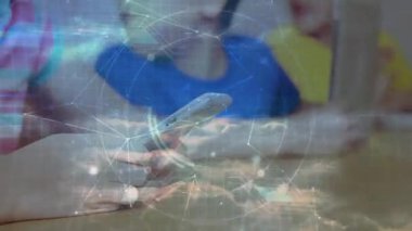 Akıllı telefonları ve tabletleri dinleyen ve eğitimde ahşap masa üzerinde ağ örtüşmesi başlatan çocuklar. Çocuklar, teknoloji, bağlantı, eğitim, işbirliği, dijital, yenilik