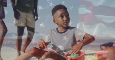 Çocuk kırmızı küreği kullanarak kumdan kale inşaatında aile eğlencesi için bayrak sallıyor. Kumsal, kumdan kale, çocukluk, aile, boş zaman, açık hava, yaz