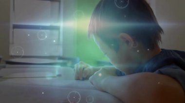 Çocuk masasında kalemle çizim yapıyor parlak daireler çiziyor ve eğitim teknolojisini görselleştiriyor. Dijital, geleceksel, yenilik, teknoloji, öğrenme, yaratıcılık, gençlik