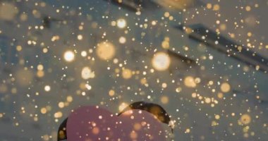 Pembe kalp kesiği taşıyan, altın rengi kıvrımlı bir çift pazarlama için yaklaşan bir kalp. Romantizm, şefkat, yakınlık, kutlama, kış modası, duygusal bağ, aşk jesti