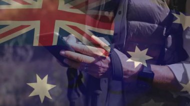 Avustralya bayrağı teknolojik navigasyon için animasyon yaparken akıllı telefon kaldıran ve dinleme yapan bir kadın. Macera, açık hava, keşif, fitness, vahşi doğa, teknoloji, aktif