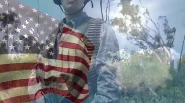 Asker ormanı tararken yukarı doğru bakan bir kamera ve bayrak kaplaması savunmaya hazır olduğunu gösteriyor. Vatanseverlik, güç, direnç, hazırlık, açık hava, taktik, yiğitlik