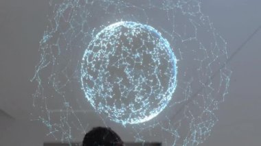 Tıbbi ekip dönen ağ küresinin arkasına geçip veri örneklerini incelemek için düğümleri tıkırdatıyor. Teknoloji, işbirliği, sağlık, yenilik, veri, bilim, dijital