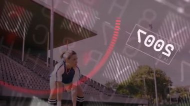 Dişi futbolcu topun üzerine çömelmiş, yukarıdan kaldırıyor, tatbikat için animasyon kaplamalar sergiliyor. Sporcu, antrenman, spor, spor, açık hava, dinamik, kararlılık