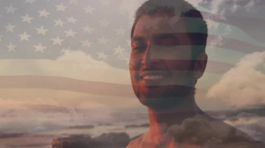 Gün batımında üstsüz bir erkek teknoloji bayrağını kapatıyor ve kahkahaya dönüşüyor. Vatanseverlik, dinginlik, tefekkür, minimalist, dijital alarm, denizci, duygusal