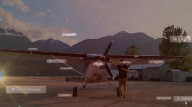 Erkek, günbatımı pistinde yüzen sosyal medya rozetleri gösteren sahne uçağıyla akıllı telefonu kontrol ediyor. Havacılık, seyahat, manzara, açık hava, teknoloji, iletişim, macera