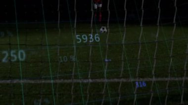 Futbol oyuncusu topa vurmadan önce spor teknolojisi ölçümlerine tepki veriyor. Sporcu, müsabaka, stadyum, dijital, yenilik, performans, gece