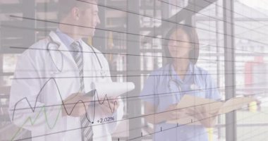 Doktor tableti işaret ediyor ve hemşire dosyaları çeviriyor. Tıbbi analizde finans grafiği ortaya çıkıyor. Tıbbi, işbirliği, veri, teknoloji, profesyonel, sağlık, analiz