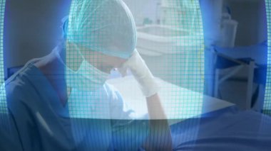 Muayene odasında stres gösteren titreşimli holografik ızgara görünce alnını ovuşturan bir kariyer doktoru. Tıbbi, sağlık, teknoloji, klinik, tanı, fütüristik, profesyonel