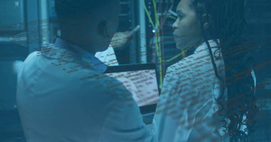 Pointing techs in lab coats examining server racks and Ethernet cables in server room, with laptop. Technology, data, infrastructure, cybersecurity, innovation, digital, networking