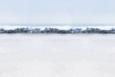 Düz tasarım, dalgaların hafifçe kırılışıyla soluk kumlu plajda uzanan kayalık dalgaları gösteriyor. Deniz manzarası, kıyı manzarası, minimalizm, sükunet, doğa, açık hava, dinginlik