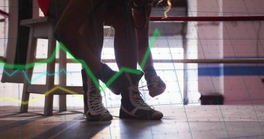 Yüksek topuklu boks ayakkabıları bağlamak, atletik şortlu boksör ring platformunda grafiklerle çömelmek. Atletizm, spor giyim, fitness, antrenman, minimalist, dinamik, sağlıklı