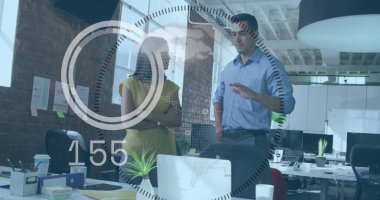 Mavi gömlekli adam ve sarı giysili kadının açık ofiste grafiklerle dizüstü bilgisayarı kullanması. İşbirliği, takım çalışması, modern çalışma alanı, dijital teknoloji, profesyonel çevre, yaratıcı endüstri, iş iletişimi