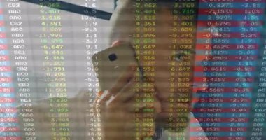 Akıllı telefonu elinde tutan adam aramayı başlatıyor ve ofisteki mali verileri inceliyor. İş, finans, analitik, teknoloji, şirket, iletişim, modern