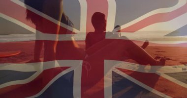 Union Jack 'in açılışı günbatımı sahnesinde çift arkasını yaslayarak dinleniyor. Romantizm, rahatlık, sükunet, siluet, sahil, tatil, sükunet