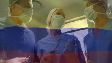 Merkez cerrah ışıkları kontrol ediyor ve forseps kaldırıyor. Meslektaşları ameliyathanede hasta hazırlıklarına yönlendiriyor. Tıbbi ekip, işbirliği, profesyonellik, steril çevre, kesinlik, hastane, sağlık hizmetleri