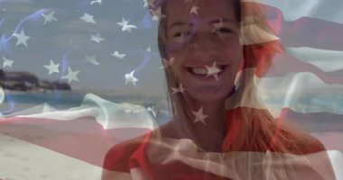 Seyahat mankeni kumlu sahil esintisinde saçlarını tarıyor, bayrak sallayarak ufuk çizgisine bakıyor. Plaj, dinginlik, açık hava, moda, yaşam tarzı, ufuk, canlılık