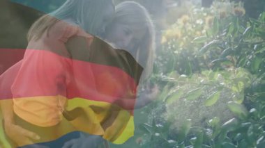 El sallayan anne, kucağında kız çocuğu, gül çalılıklarında yaşam tarzı için kalp şeklini oluşturan bayrak. Vatanseverlik, aile, beslenme, şefkat, sıcaklık, sükunet, açık hava