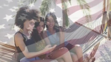 Üç arkadaş akıllı telefonları dinleyip plaj hamağında sallanırken sörf dükkanı arıyor. Beraberlik, boş zaman, açık hava, tatil, rahatlama, canlı, neşeli