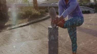 Bir kadın Plaza 'ya geliyor ve Bollard' ın üzerinde dinleniyor. Spor yapmak için bacak kaslarını esnetiyor. Atletik, sağlıklı, esneme, açık hava, gündelik, enerji, gençleşme