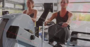Spor salonunda senkronize kürek çeken iki kadın animasyon veri küresi üretiyor. Fitness, atletizm, yenilik, teknoloji, takım çalışması, refah, modern