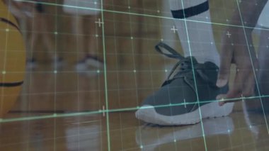 Genç çocuk basketbol sahasında ayakkabısını bağlamayı bitiriyor basketbol antrenmanına hazırlanıyor. Atletizm, takım çalışması, yoğunluk, spor, kararlılık, eğitim, hareket