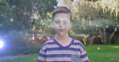 Bahçede kıvılcımlar saçan bir çocuk ve eğlence için göğsünü süpüren gökkuşağı alevi. Neşeli, kaprisli, canlı, peri masalı, büyülü, masum, açık havada